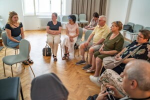 Zážitkovo – vzdelávací workshop pre nevidiacich: Dotkni sa hudby, skupina návštevníkov podujatia sediaca v kruhu