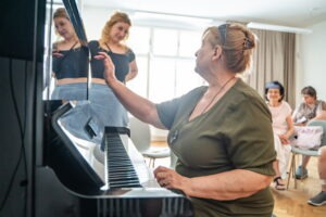 Zážitkovo – vzdelávací workshop pre nevidiacich: Dotkni sa hudby - žena sediaca pri klavíri