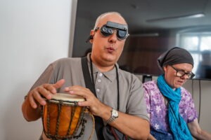 Zážitkovo – vzdelávací workshop pre nevidiacich: Dotkni sa hudby, muž hrá na bubienok