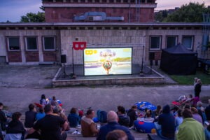 Filmové leto Mičurin, premietanie v Amfiteátri Mičurin - obrazovka s upútavkou na program Bratislavského kultúrneho leta