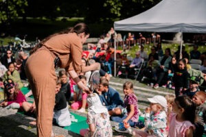 Nedeľná desiata 3. 8. 2025, Féder Teáter – ZaHNIEZDI SA!  Herečka ukazuje deťom v publiku bábku