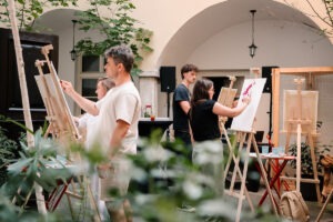 Návštevníci a návštevníčky maľujú počas Palettone workshop na Bielej 6