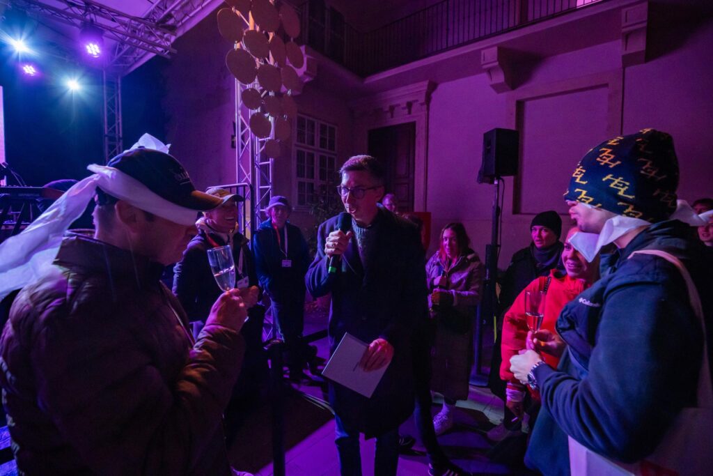 Martin Staňo počas súťaže na Festivale mladého vína. Súťažia dvaja návštevníci, ochutnávajú víno so zaviazanými očami