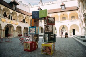 Umelecká inštalácia na námestí z kociek rôznych farieb s vyobrazením