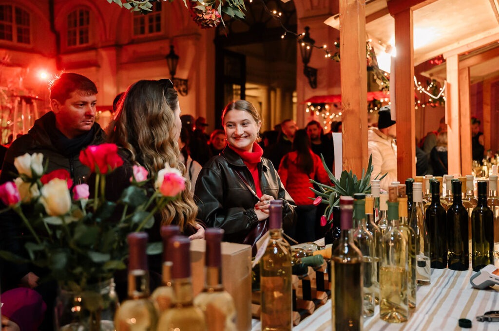 Ženy a muž pri stánok s predajom vín počas Festivalu mladého vína 2025