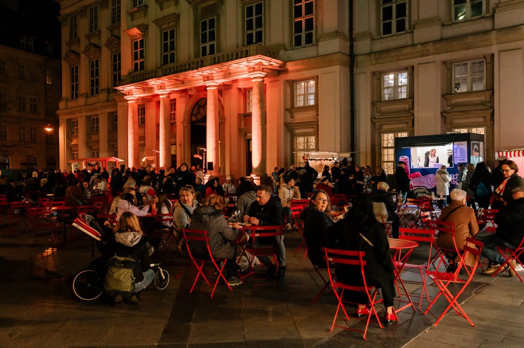Primaciálne námestie plné návštevníkov*čok sediacich na červených stoličkách počas Festivalu mladého vína 2025