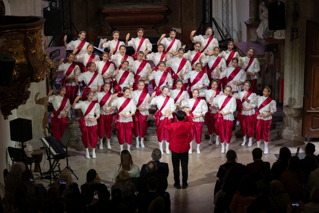 Medzinárodné festivaly pre spevácke zbory a orchestre 2025, na fotografii je spevácky zbor v červeno-bielom oblečení