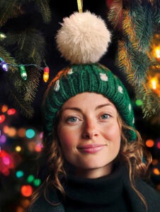 Dievča v čiapke, v pozadí vianočné svetielka